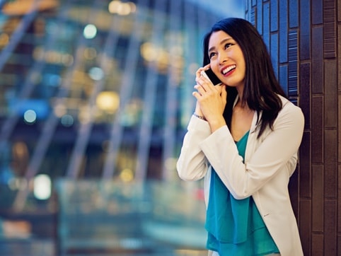 Woman standing near a wall on a phone call